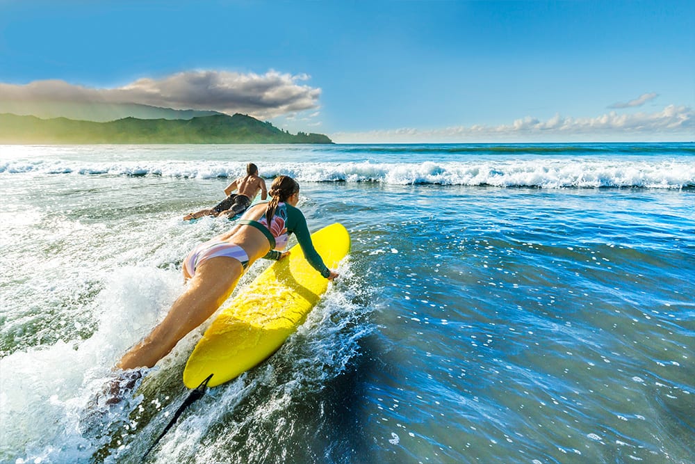 Pareja practicando surf en Hanalei Bay, Hawái